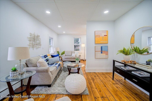living area with recessed lighting, baseboards, and light wood-style flooring
