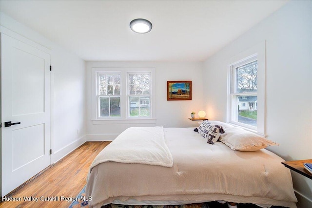 bedroom with baseboards and light wood-type flooring