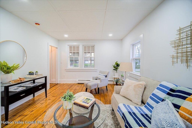 living area with recessed lighting, baseboard heating, and wood-type flooring