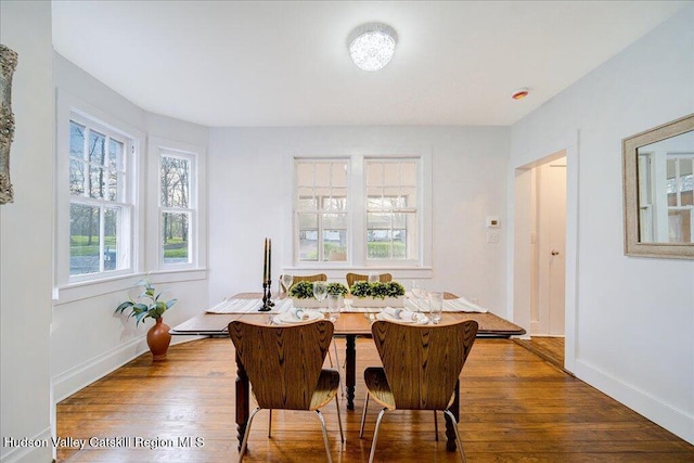 dining room with baseboards and wood finished floors