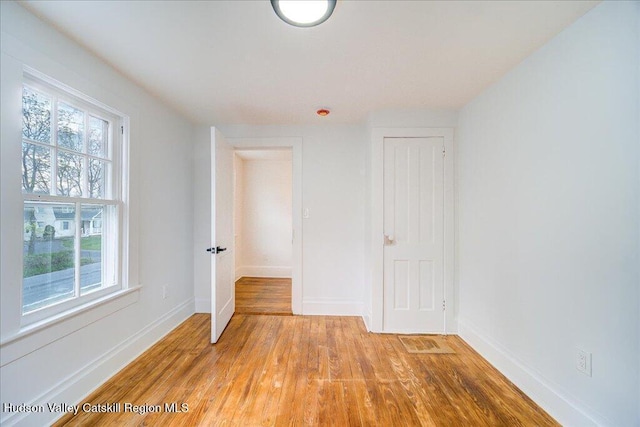 spare room with baseboards, visible vents, light wood-style flooring, and a wealth of natural light