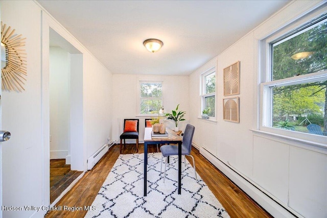 home office with baseboards, a baseboard heating unit, and wood finished floors