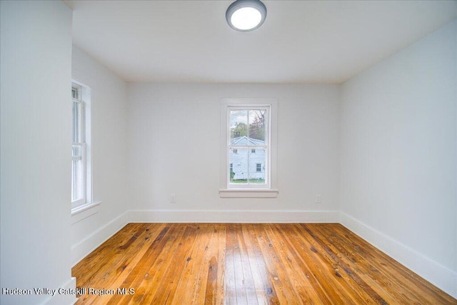 empty room featuring baseboards and hardwood / wood-style flooring