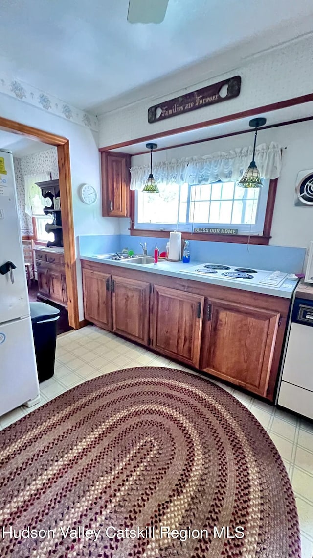252 Rte 199, Red Hook, NY 12571 - kitchen with white appliances, brown cabinetry, hanging light fixtures, and light countertops