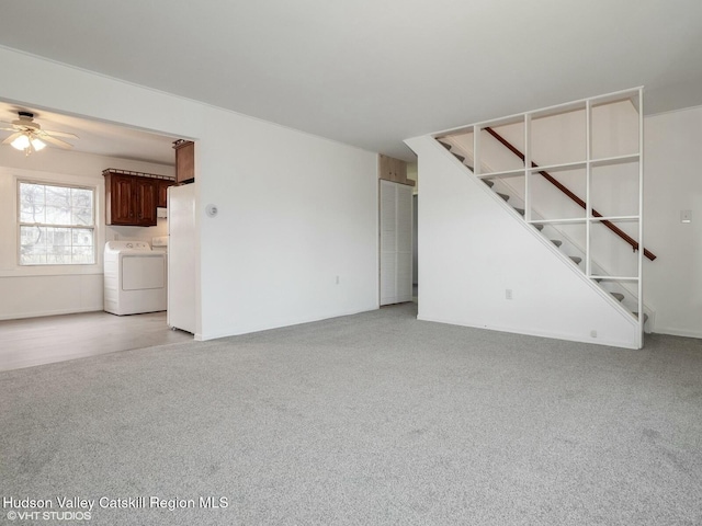 unfurnished living room featuring washer and dryer, light colored carpet, a ceiling fan, and stairs