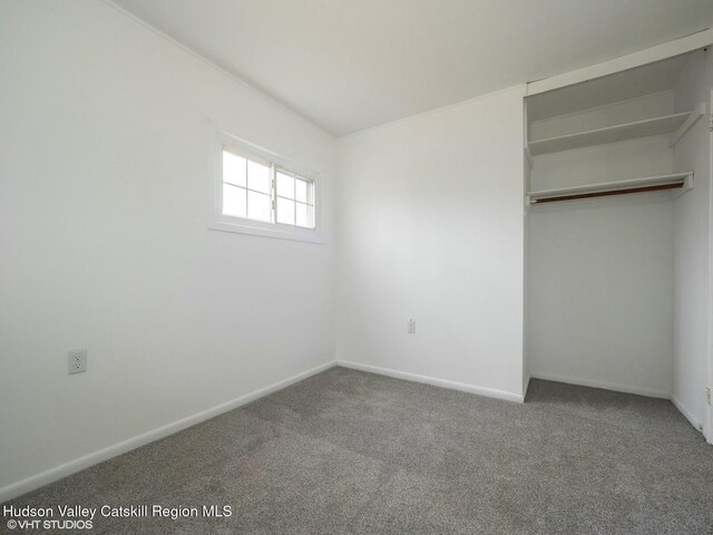unfurnished bedroom with a closet, carpet, and baseboards
