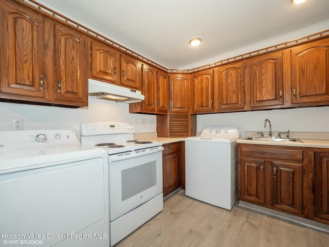 laundry area featuring a sink, washer and clothes dryer, light wood finished floors, and laundry area