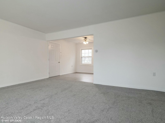 unfurnished room featuring carpet flooring, ceiling fan, and baseboards