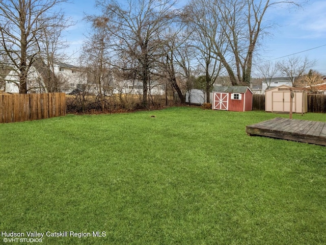 view of yard with a storage shed, fence, and an outdoor structure