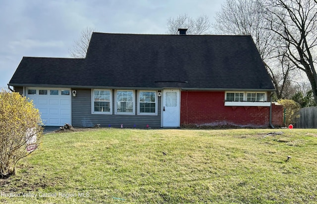 view of front of property with aphalt driveway, a front yard, fence, brick siding, and an attached garage