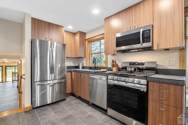 106 Earles Ln, Gilboa, NY 12076 - kitchen with appliances with stainless steel finishes, a sink, dark countertops, brown cabinets, and recessed lighting