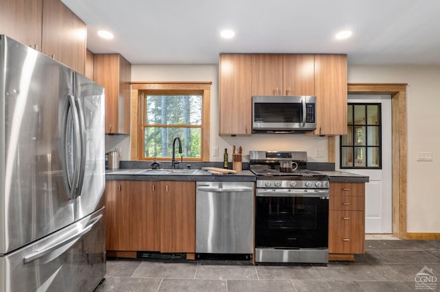 106 Earles Ln, Gilboa, NY 12076 - kitchen featuring appliances with stainless steel finishes, a sink, dark countertops, brown cabinets, and recessed lighting