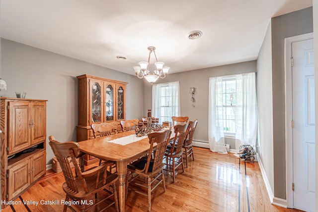 319 Garrison Woods Ln, Wallkill, NY 12589 - dining area with baseboards, a notable chandelier, light wood finished floors, and visible vents