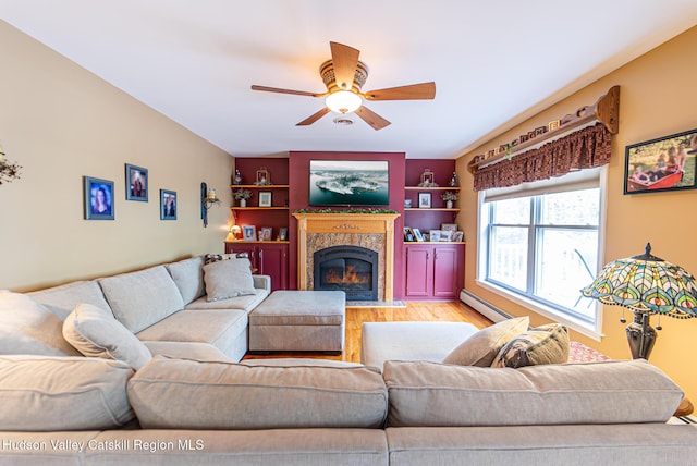 319 Garrison Woods Ln, Wallkill, NY 12589 - living room featuring wood finished floors, a ceiling fan, a premium fireplace, built in features, and baseboard heating