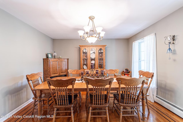 319 Garrison Woods Ln, Wallkill, NY 12589 - dining area featuring baseboards, a chandelier, wood finished floors, and a baseboard radiator