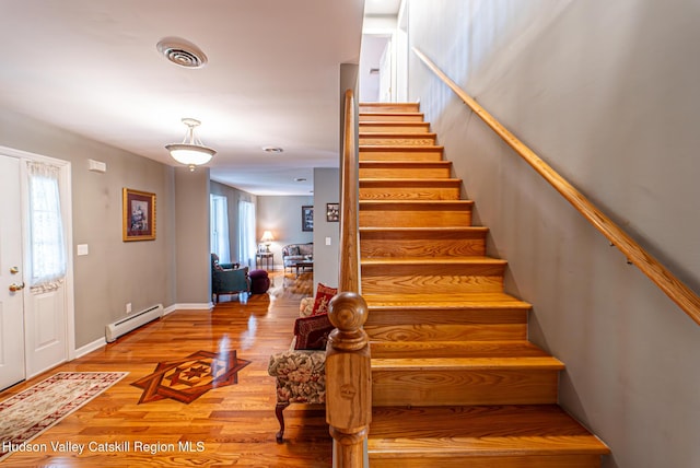 319 Garrison Woods Ln, Wallkill, NY 12589 - stairway with wood finished floors, visible vents, and a baseboard heating unit