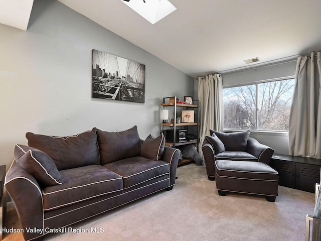 living room featuring carpet floors and vaulted ceiling with skylight