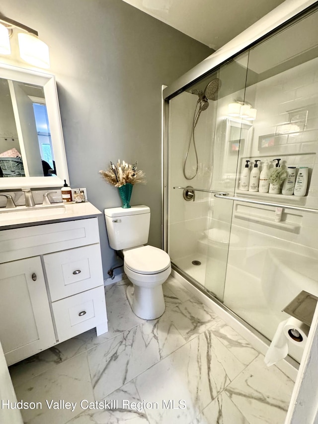 bathroom with toilet, an enclosed shower, and vanity