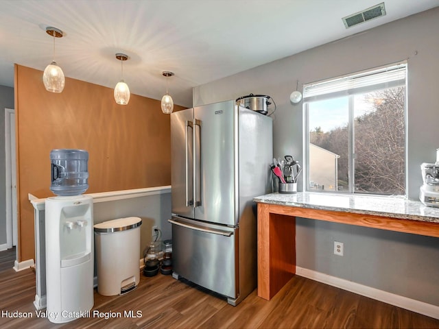 kitchen with high end refrigerator, light stone countertops, dark hardwood / wood-style flooring, and hanging light fixtures