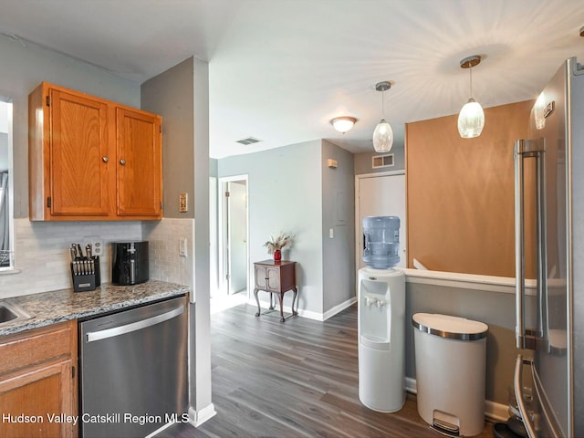 kitchen featuring appliances with stainless steel finishes, pendant lighting, dark hardwood / wood-style flooring, and backsplash