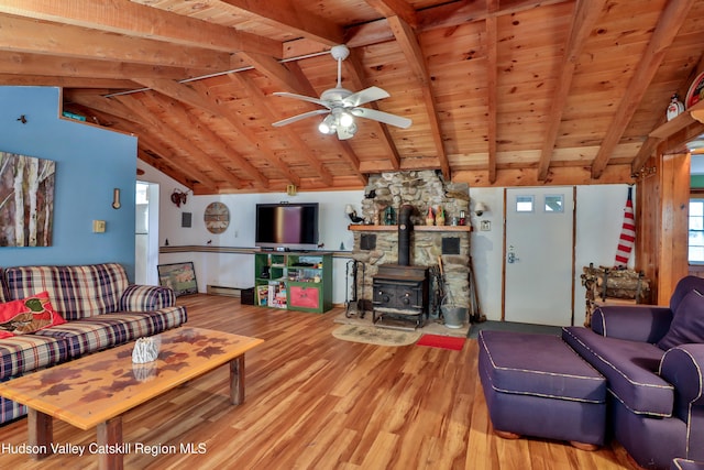 living room with a wood stove, ceiling fan, wooden ceiling, lofted ceiling with beams, and hardwood / wood-style flooring