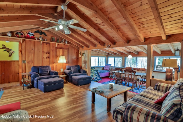 living room with wood walls, wooden ceiling, lofted ceiling with beams, hardwood / wood-style flooring, and ceiling fan