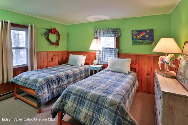 bedroom with carpet flooring, wooden walls, and ornamental molding