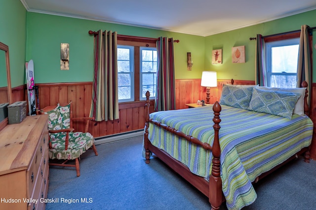 bedroom with crown molding, carpet, wood walls, and a baseboard heating unit