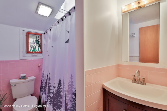 bathroom with a shower with curtain, vanity, tile walls, and toilet