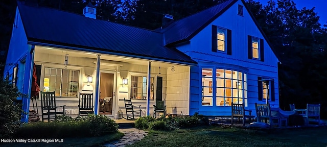 76 Smith Rd, Preston Hollow, NY 12469 - back of house at twilight with a chimney, covered porch, and a metal roof