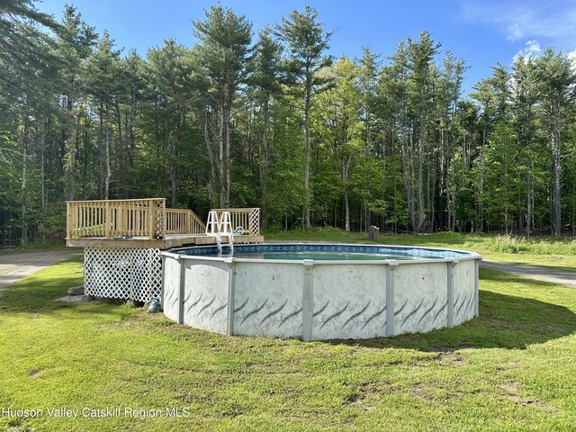 52 Bowman Rd, Chatham, NY 12037 - outdoor pool featuring a lawn, a wooden deck, and a forest view