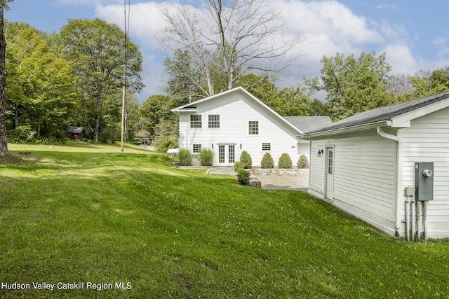 back of property with french doors and a lawn