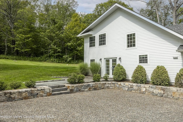 rear view of house with a lawn and french doors