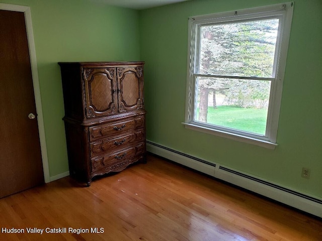 22 Katzman Rd, Ellenville, NY 12428 - bedroom featuring baseboard heating, multiple windows, and light wood-style floors