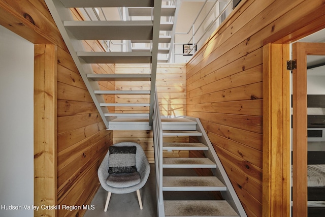 stairs featuring wood walls