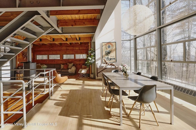 interior space with vaulted ceiling with beams and a wood stove