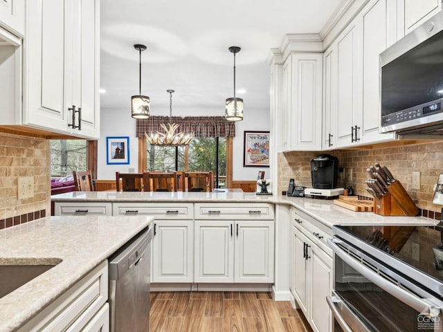 kitchen with appliances with stainless steel finishes, white cabinets, a chandelier, decorative backsplash, and recessed lighting