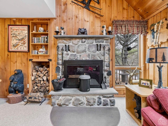 living room featuring lofted ceiling, wooden walls, carpet flooring, a fireplace, and wood ceiling