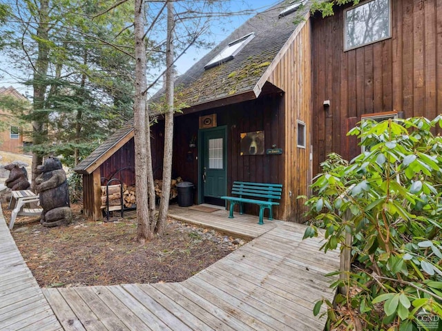property entrance featuring a shingled roof and a deck