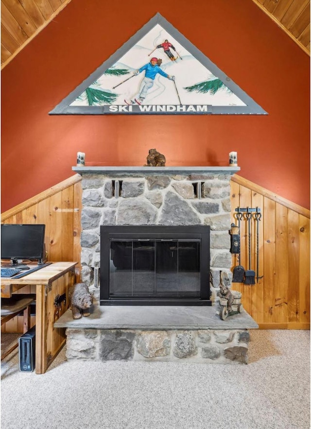 detailed view of a fireplace, carpet floors, a wainscoted wall, and wooden walls