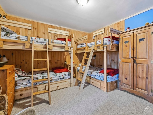 carpeted bedroom featuring wood walls