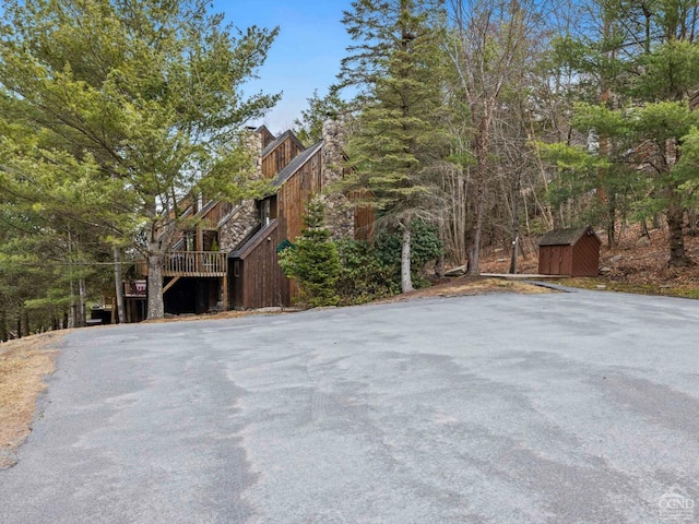 view of side of home featuring a storage shed, an outbuilding, and a chimney