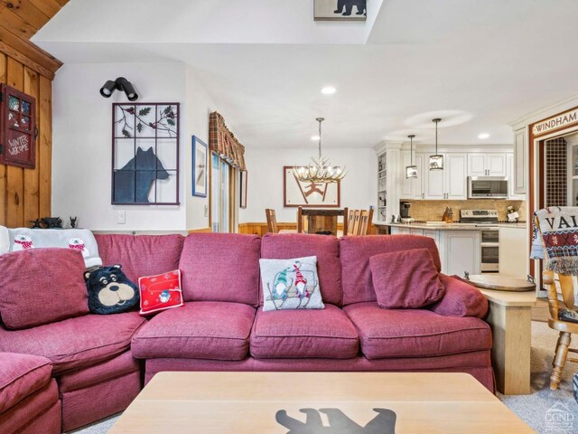 living area featuring recessed lighting, a chandelier, and wooden walls