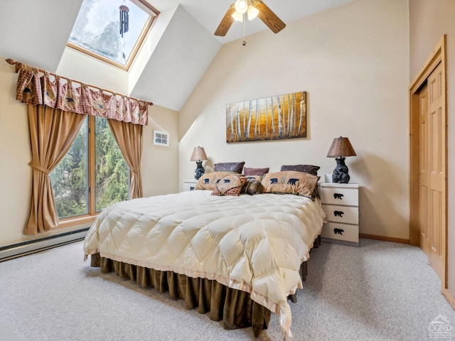 carpeted bedroom featuring vaulted ceiling, a skylight, a baseboard heating unit, ceiling fan, and baseboards