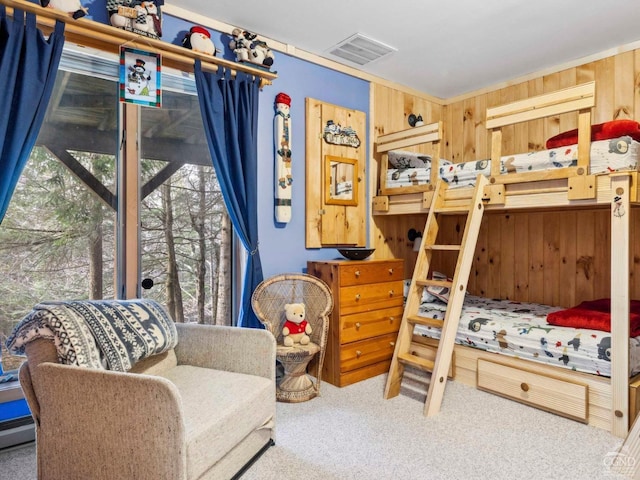 carpeted bedroom with wooden walls and baseboard heating