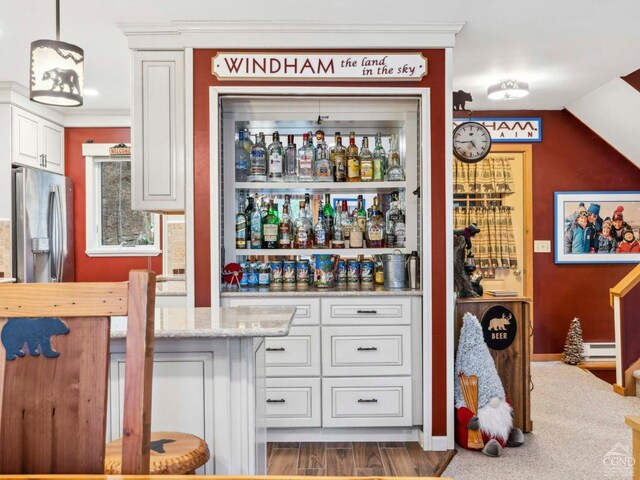 indoor bar featuring stainless steel fridge and baseboard heating