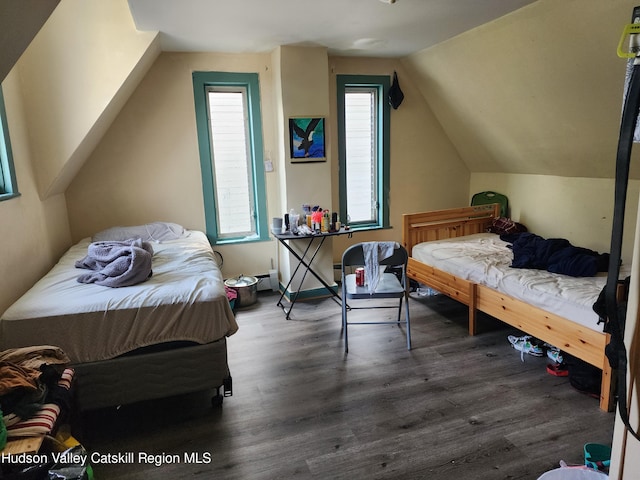 bedroom with baseboard heating, dark wood-type flooring, and vaulted ceiling