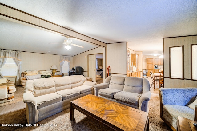 carpeted living room with a textured ceiling, lofted ceiling with beams, and ceiling fan