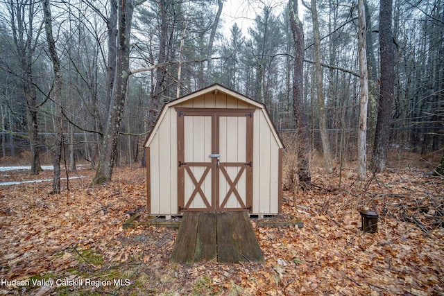 view of shed with a wooded view