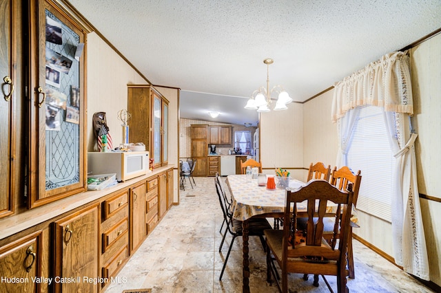 dining area with a textured ceiling, a chandelier, and ornamental molding